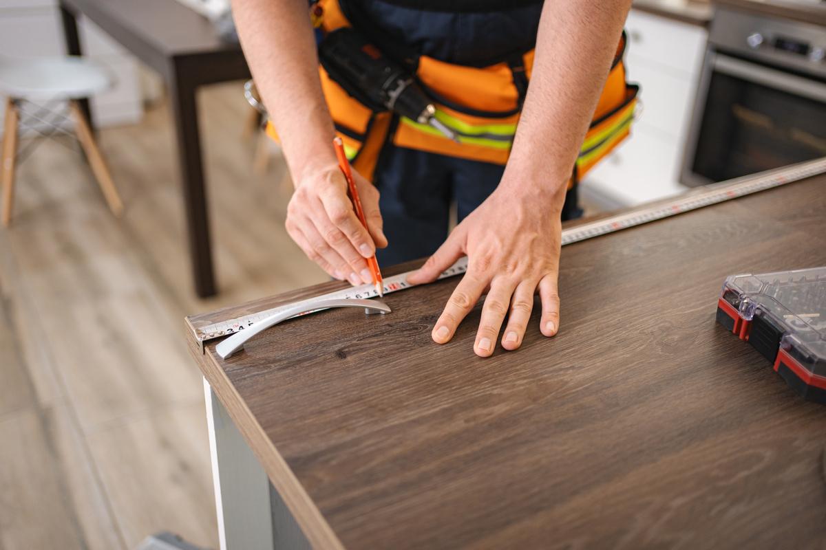 Man taking measurements of a kitchen